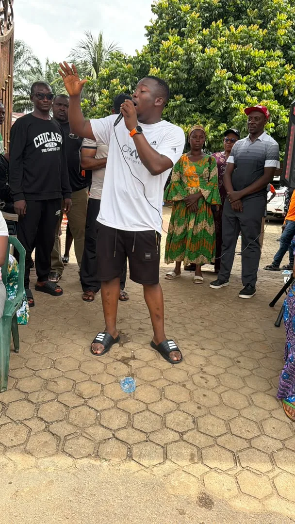 A speaker addressing community members during Holyghost Anointed Foundation relief and community outreach