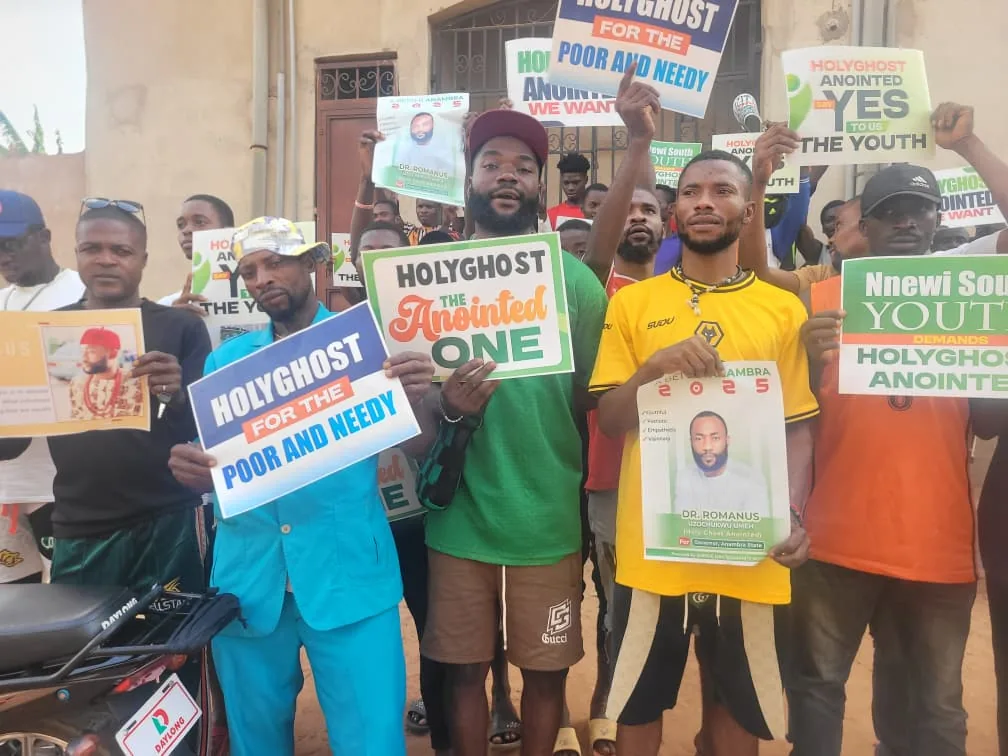 Community members holding Holyghost Anointed Foundation outreach signs in Nnewi South